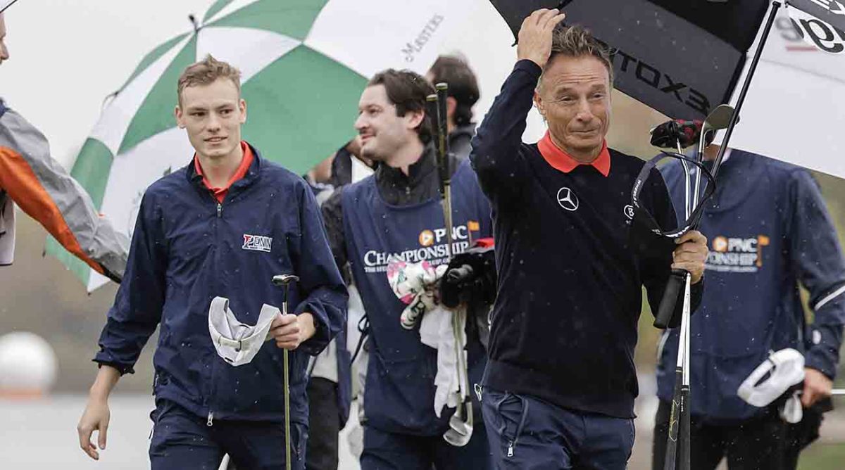 Bernhard Langer, right, and son Jason, left, walk off a green at the 2023 PNC Championship in Orlando, Fla.